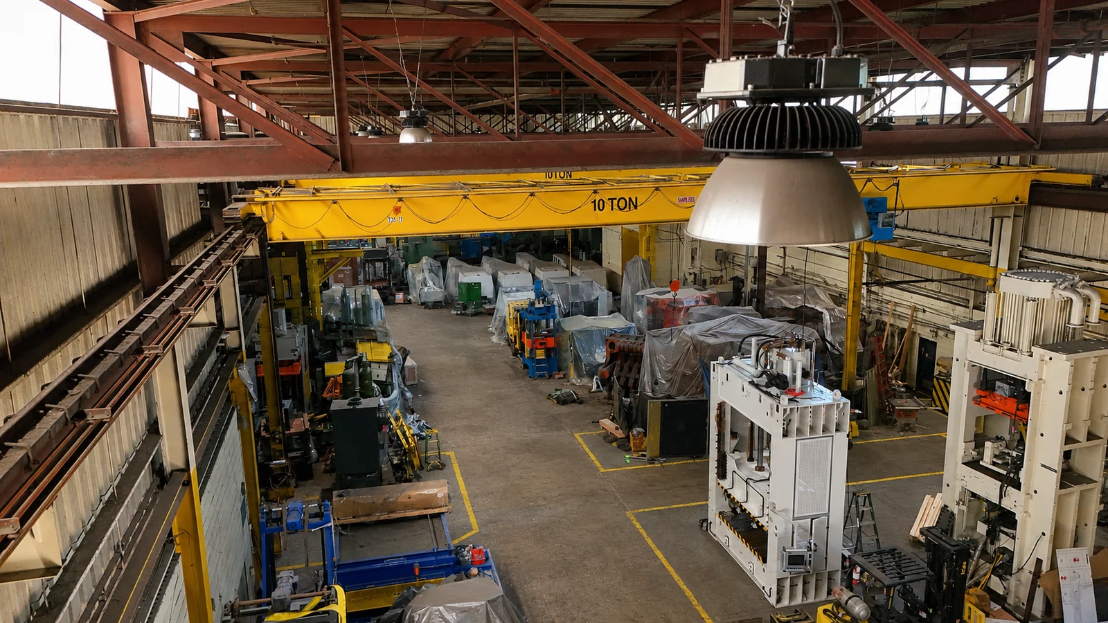 Actual Cambridge warehouse with stored industrial machines and yellow overhead cranes