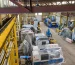 Covered CNC machines and industrial equipment arranged on the warehouse floor.