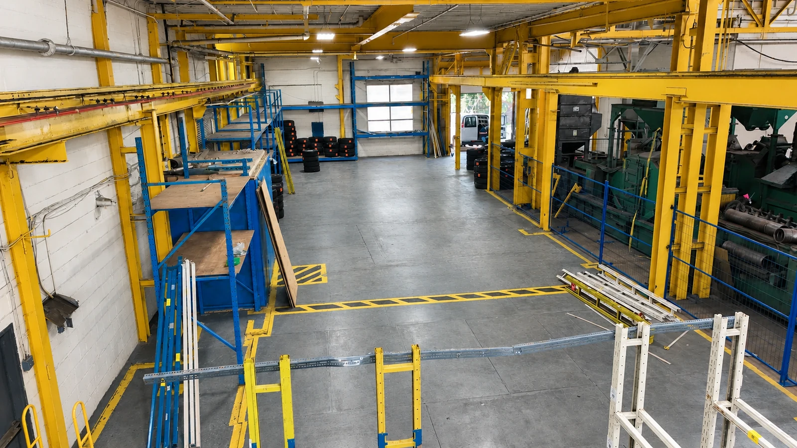Blue warehouse racking beside a concrete aisle and industrial storage area.